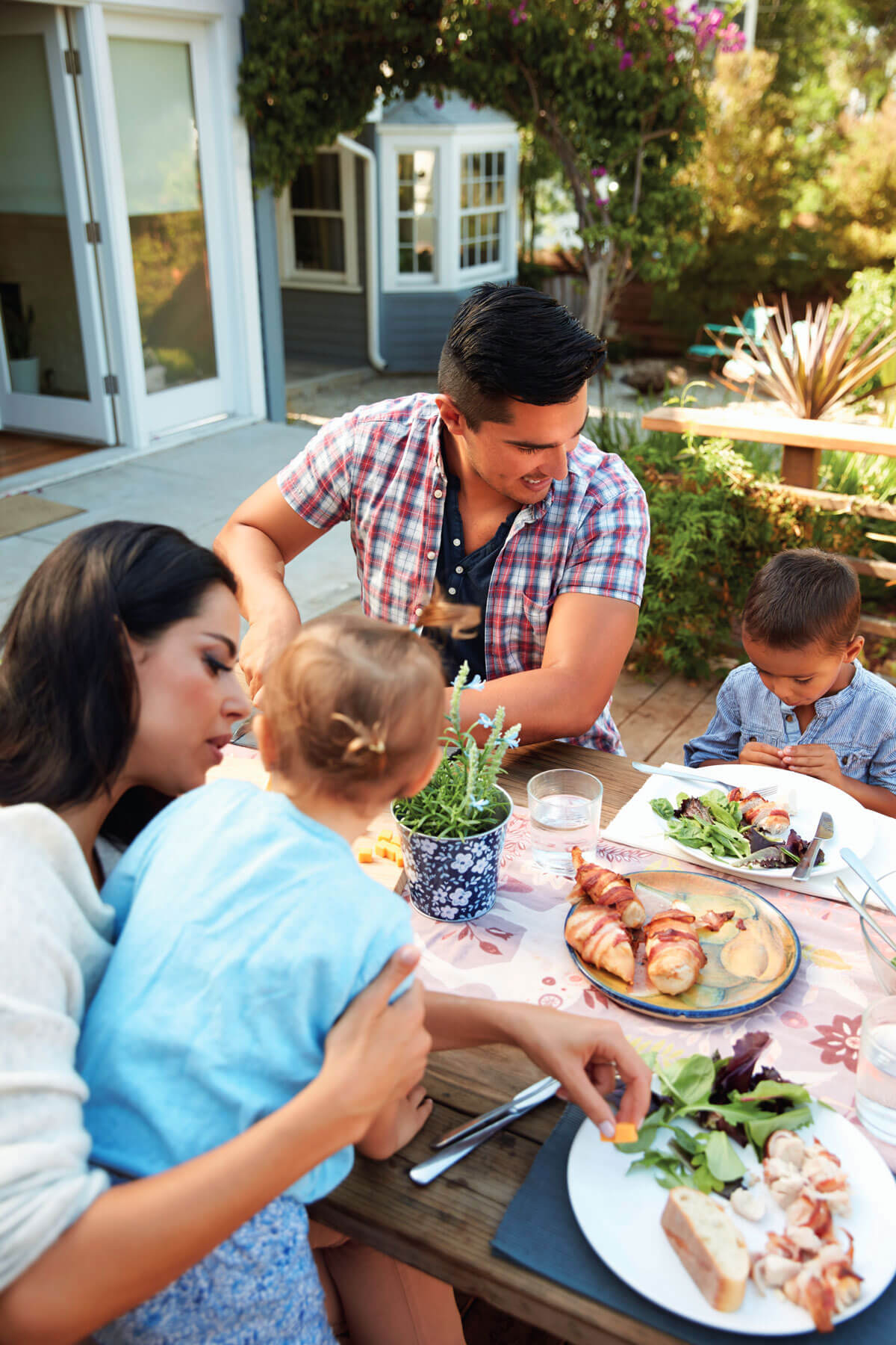 A family sits down for a meal together in the warm summer weather