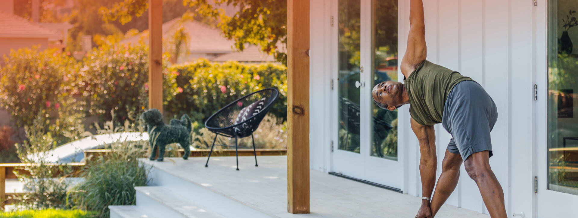 A man starting his day with a yoga session on the front porch of his Kinston home