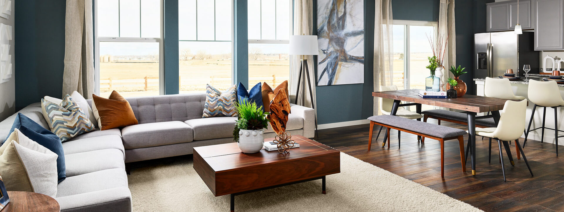 Large windows fill an open concept kitchen, living and dining room with natural light