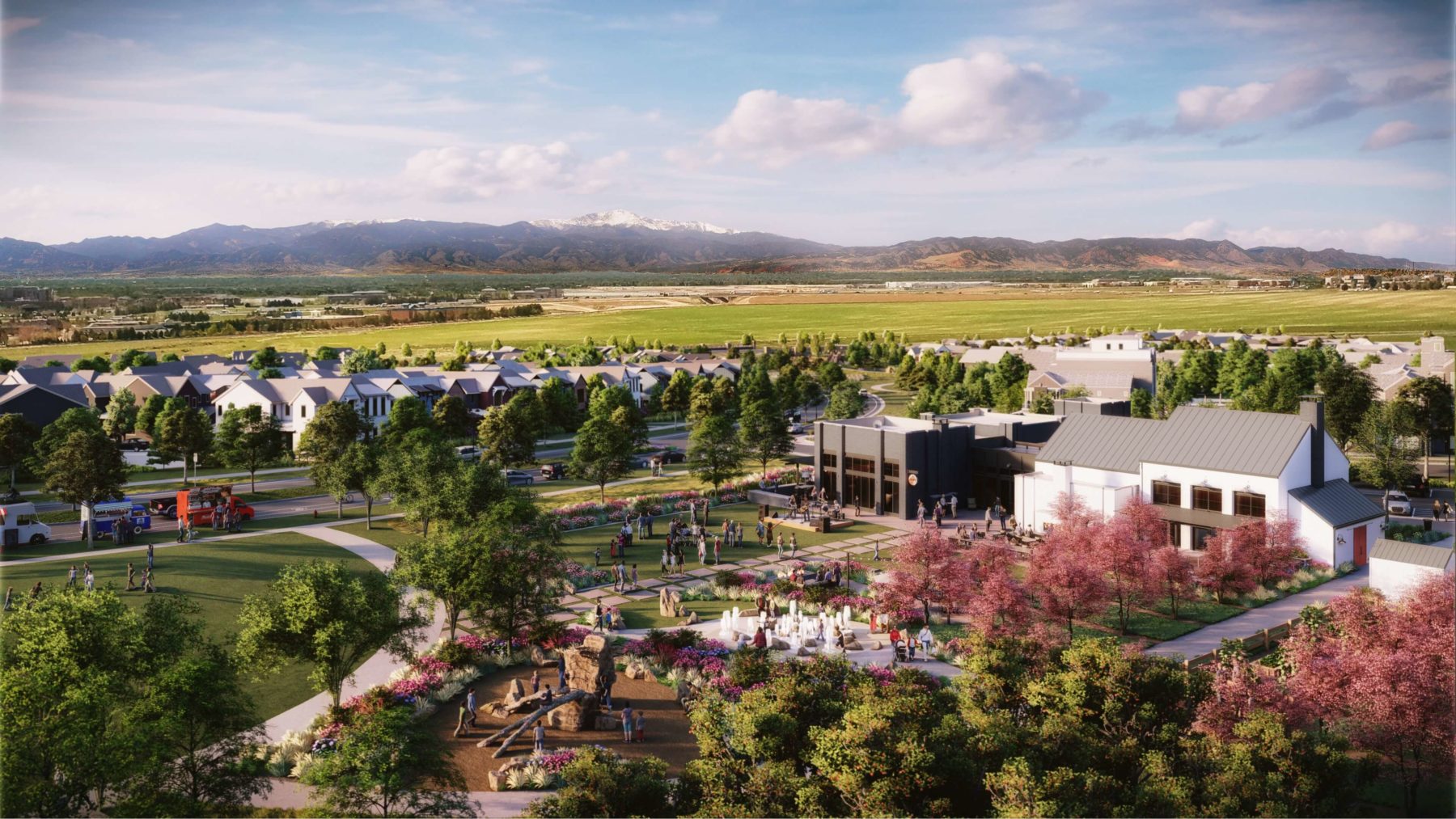 Exterior rendering of the community's welcome center, Kinston Hub, showing the future event lawn, splash pad and mountain views in the background