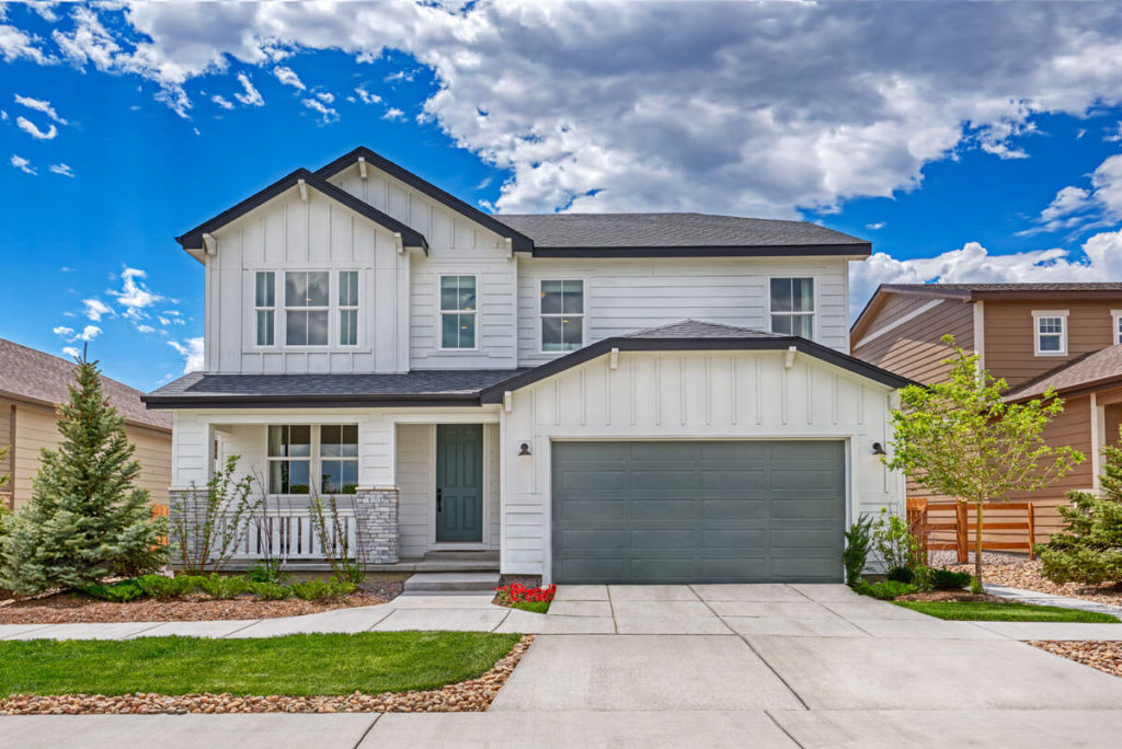 Single-family home with a white farmhouse exterior and grey garage coming soon by Richmond American Homes