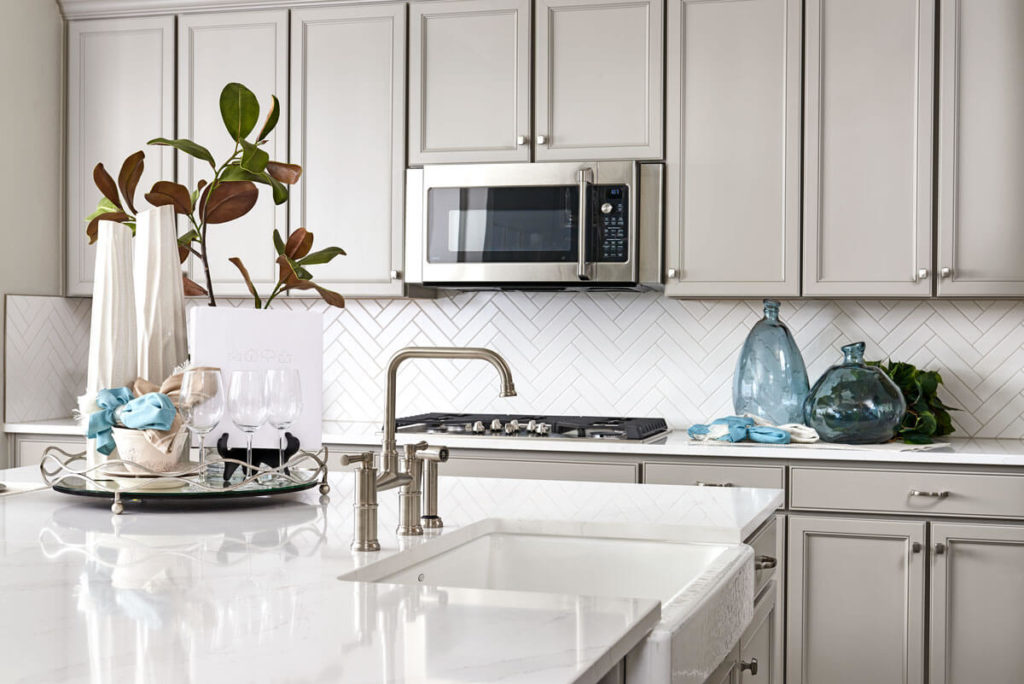 Interior photo of a Lennar kitchen with white countertops, farmhouse sink, and grey cabinets