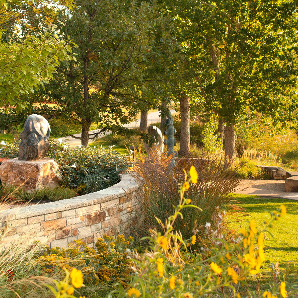 Photo of the walking trails located in Chapungu Sculpture Park in Centerra with lush green trees and flowers