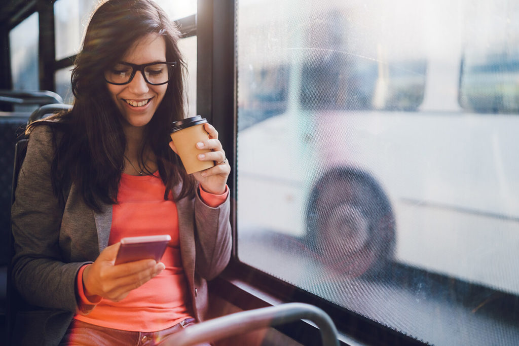 Woman drinking a coffee on a bus, headed from the future Centerra Loveland Station, coming in 2022