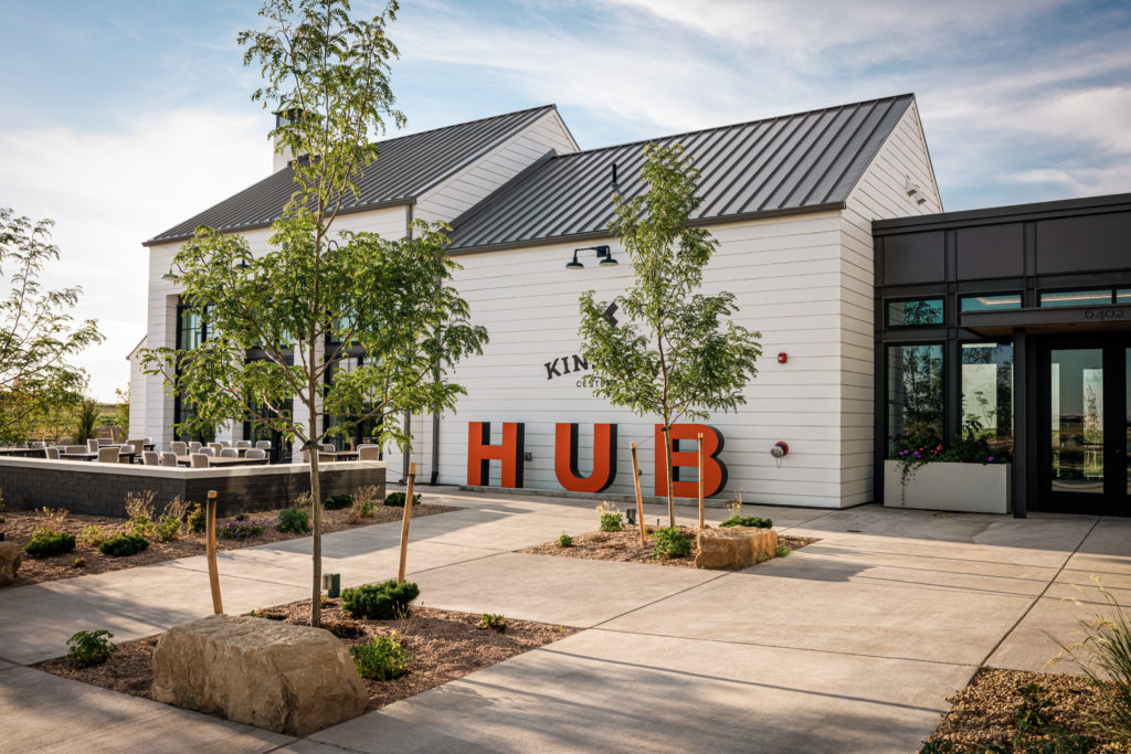 Outside view of the Kinston Hub with white siding, the community welcome center and Mountain Cowboy Brewing Company