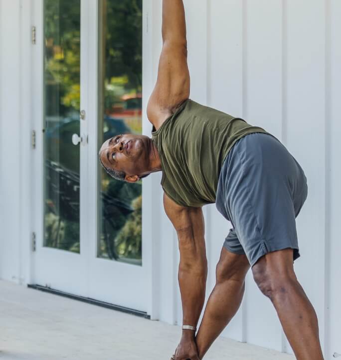 A man starting his day with a yoga session on the front porch of his Kinston home