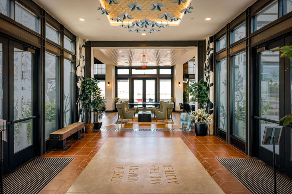 A hallway with glass doors and a chandelier.