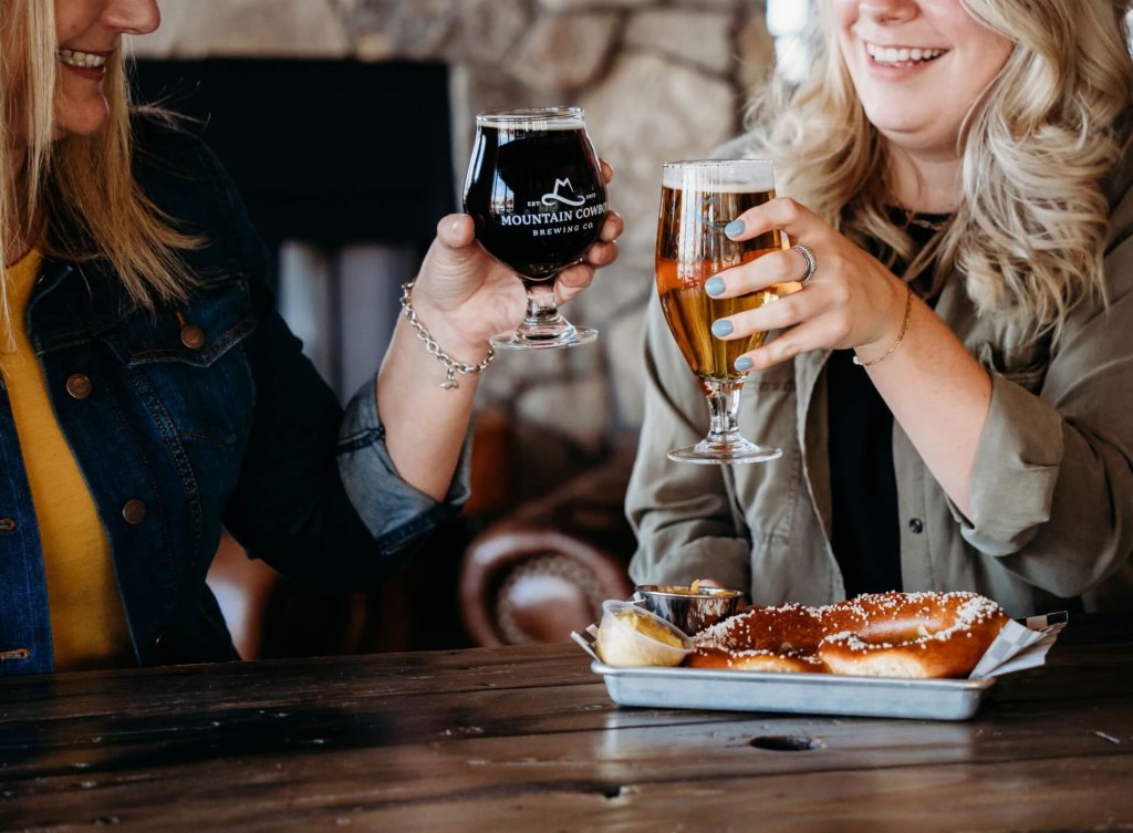 Two women cheers with beer at Kinston Hub