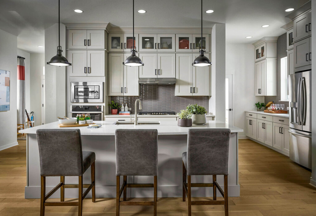 A kitchen with a center island and bar stools.