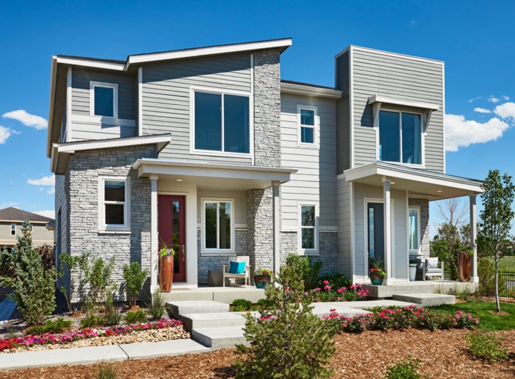 A two story home with a front porch and landscaping.