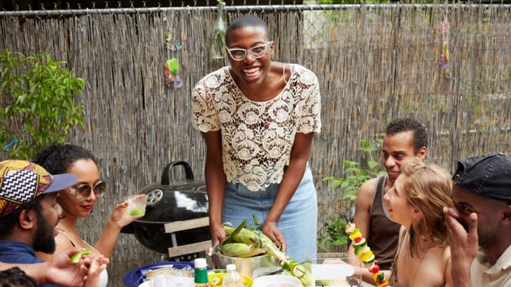 Image of woman wearing glasses eating dinner with friends