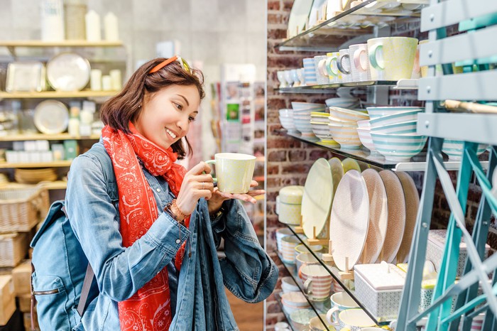 Image of a woman looking at a mug in Bed Bath & Beyond