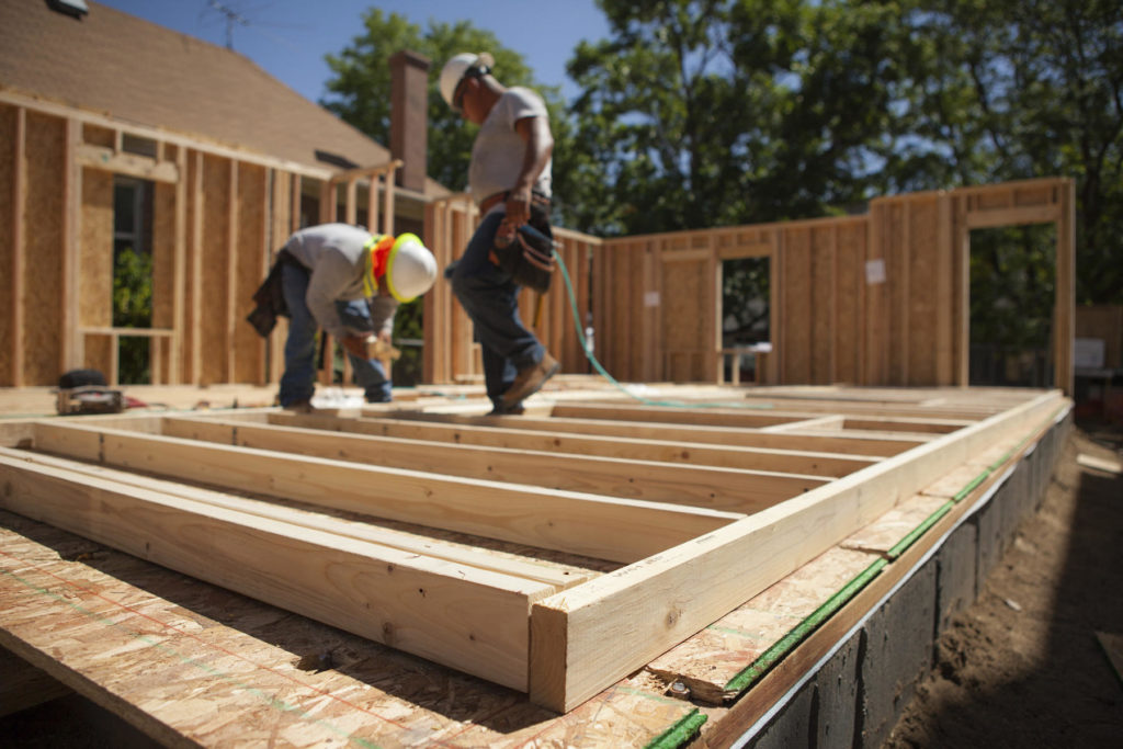 Image of two workers building a house