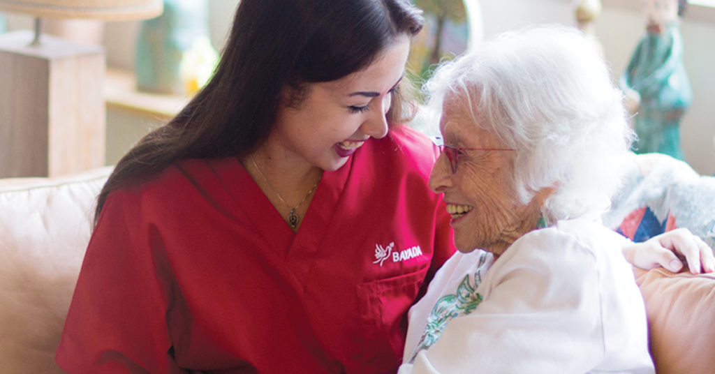 Image of elderly woman sitting with a Bayada employee