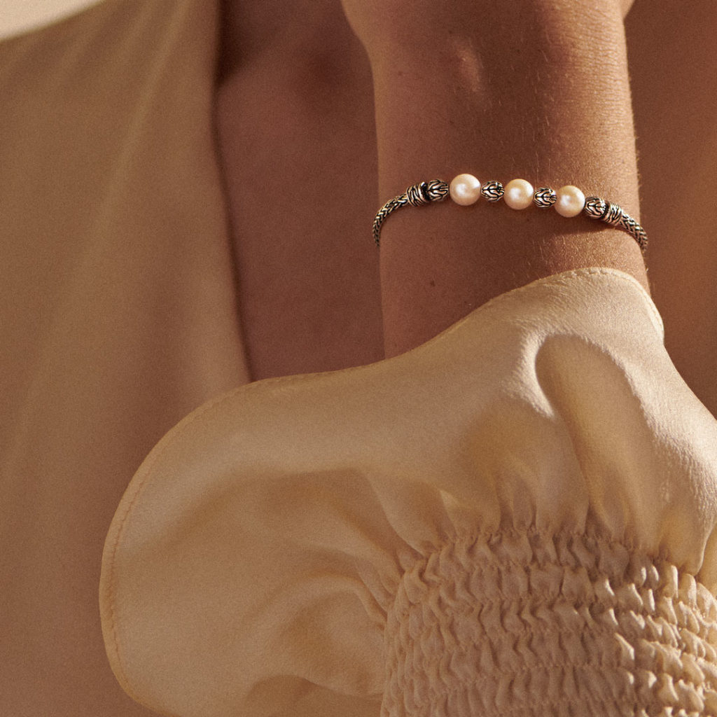 Image of a pearl and silver bracelet on a woman's wrist
