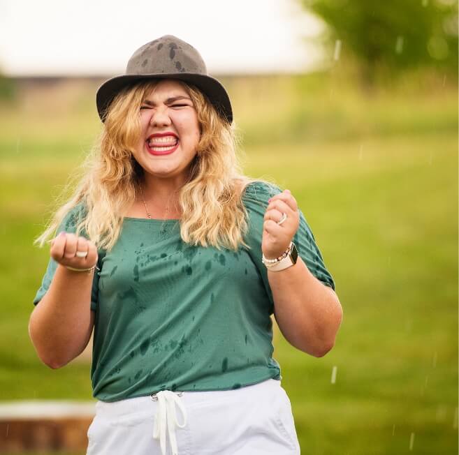 Image of woman smiling and standing in the rain