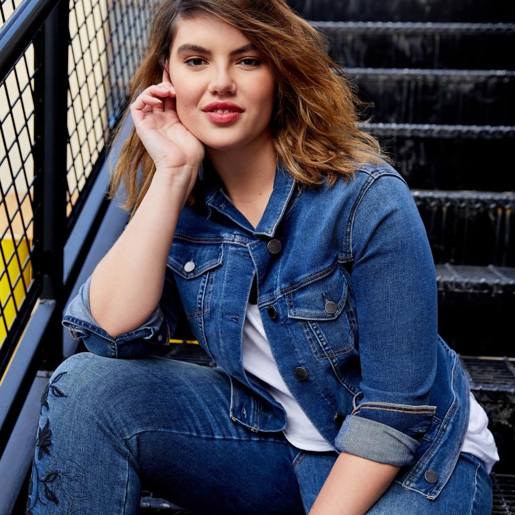 Image of woman sitting on stairs dressed in clothes from Lane Bryant store