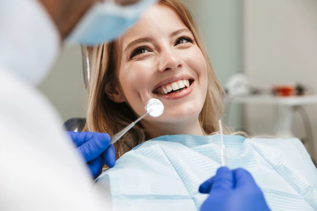 Image of smiling woman getting a dental examination
