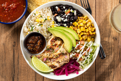 Image of a bowl from On The Border with chicken, rice, black beans, corn, guacamole, and salsa