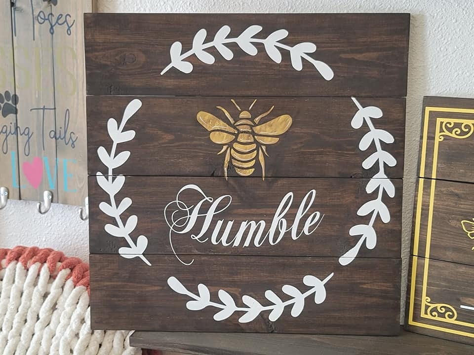 A humble wooden sign with a bee on it.