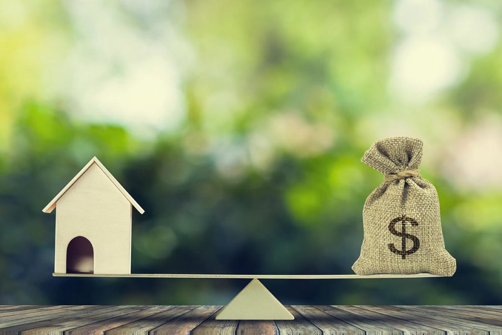 Image of a scale with a home on the left side and a bag of money on the right side