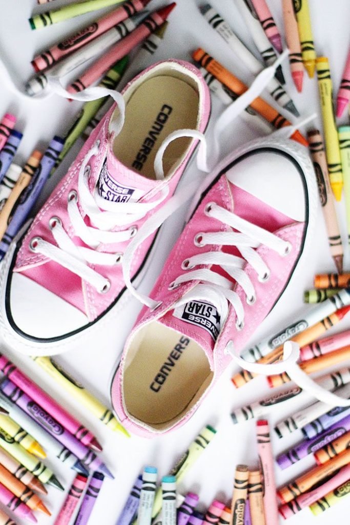 Image of pink Converse shoes with crayons spread out around them
