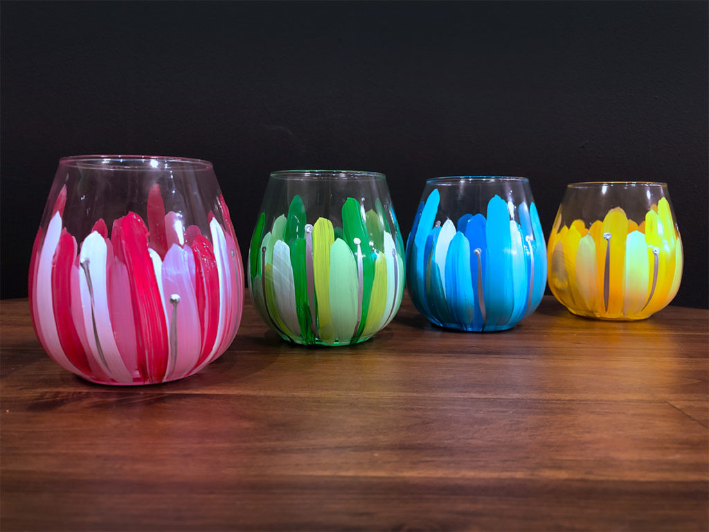 Image of wine glasses that have been painted pink, green, blue, and yellow
