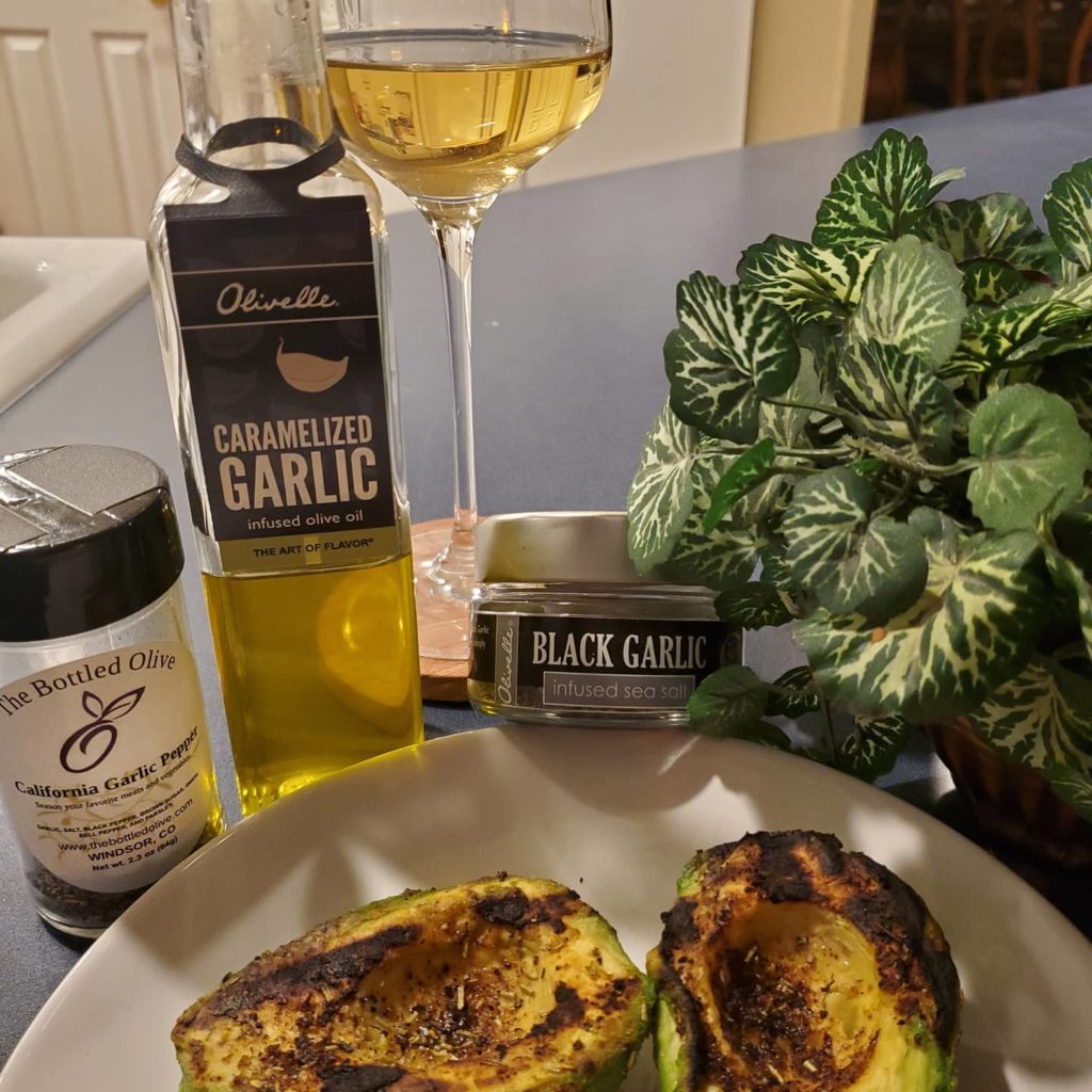 Image of a roasted avocadoe with olive oil, black garlic infused sea salt, and California garlic pepper from The Bottled Olive store