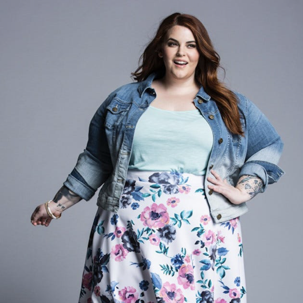A plus size woman wearing a denim jacket and floral skirt goes shopping for new homes.