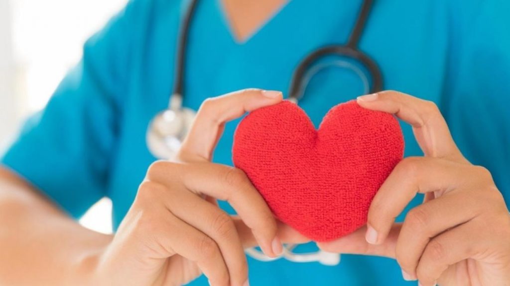 Image of a doctor holding up a fabric heart shape