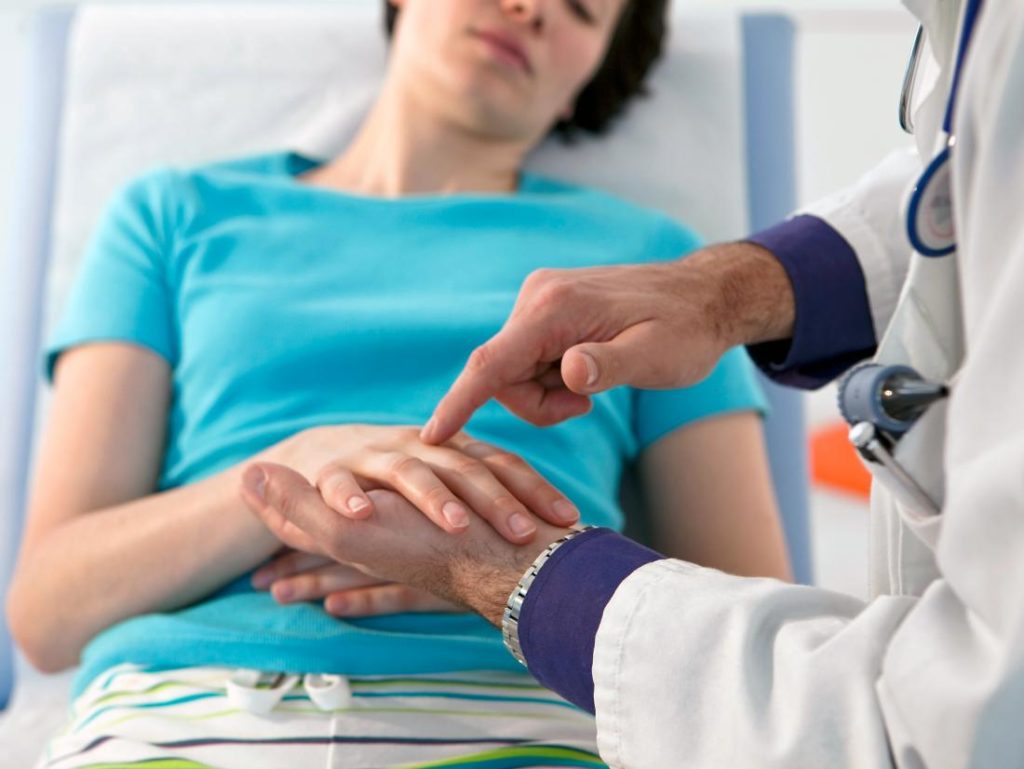 Image of doctor pointing to a patients hand