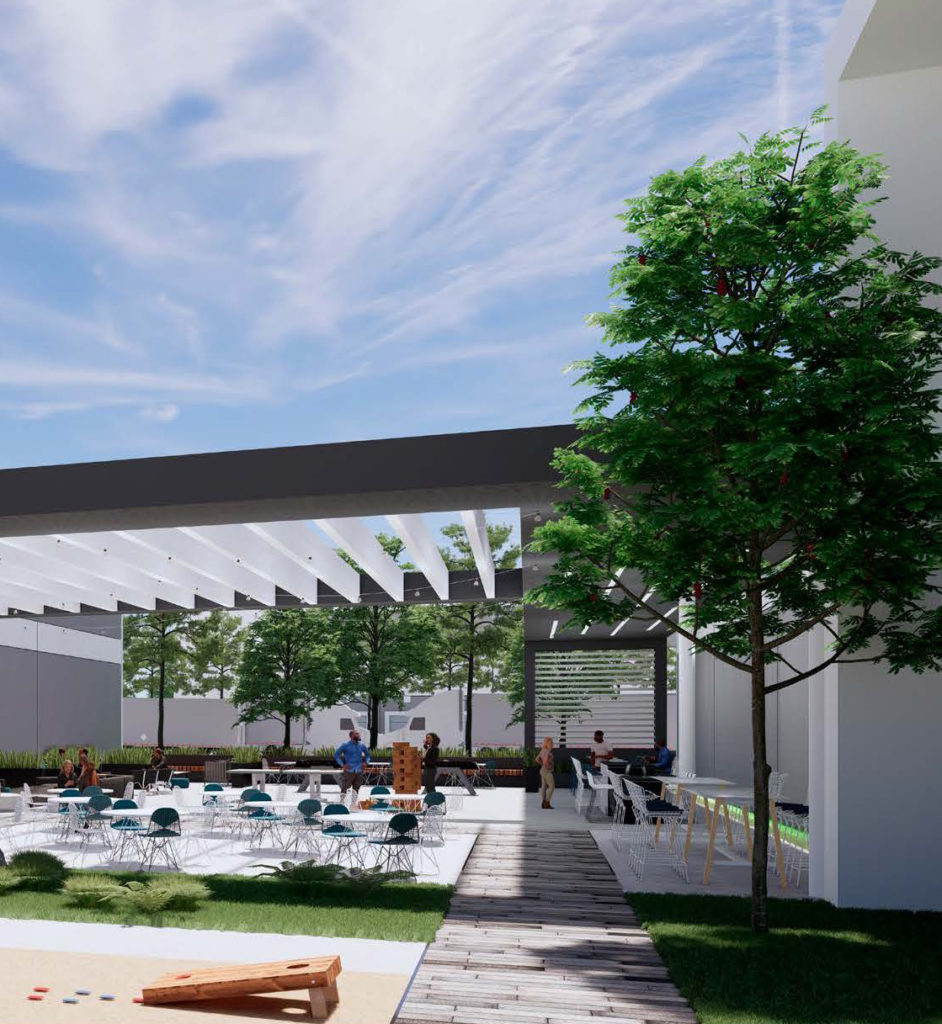 Image of people in an outdoor courtyard with tables, chairs, and cornhole set