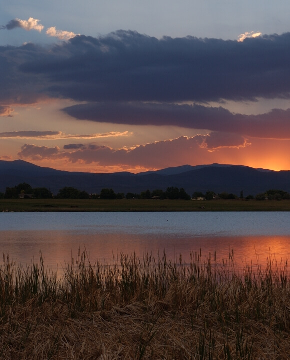 Image of a lake with a sunset over mountains