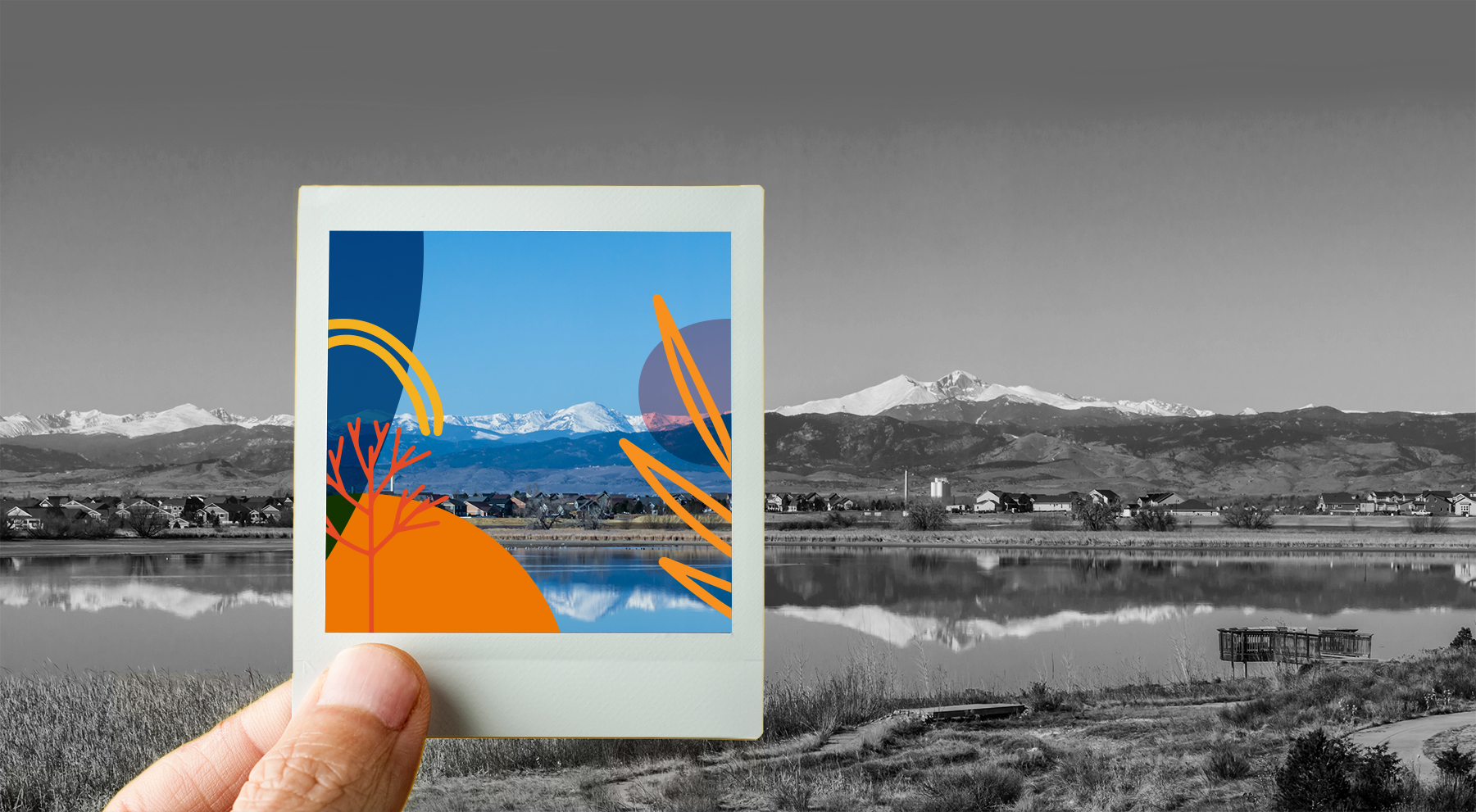 Image of a polaroid picture of mountains being held over an image of mountains