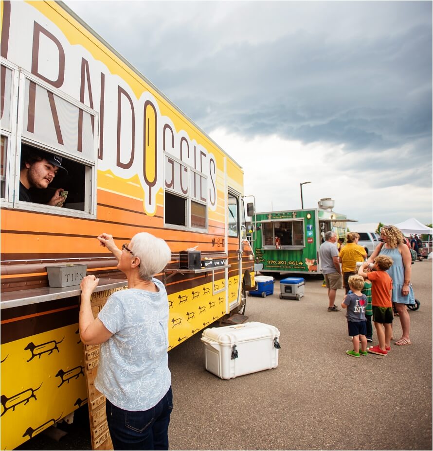 A group of people dining in front of a food truck.