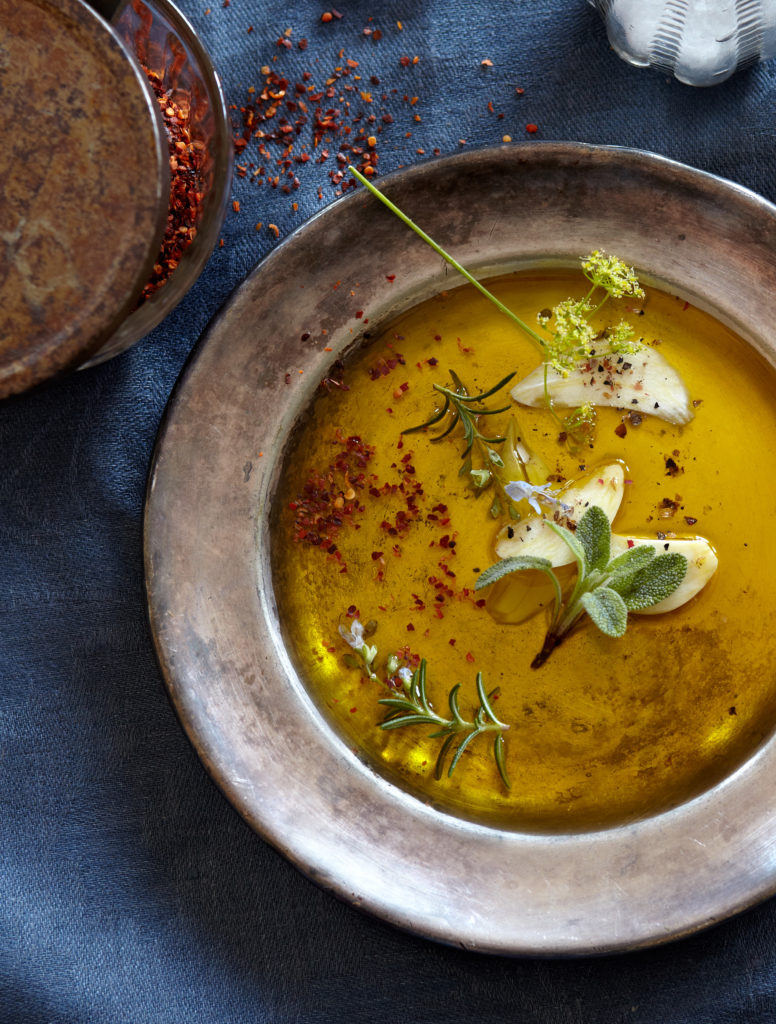 A plate with a bowl of olive oil and herbs in a dining setting at an elegant restaurant in Northern Colorado.