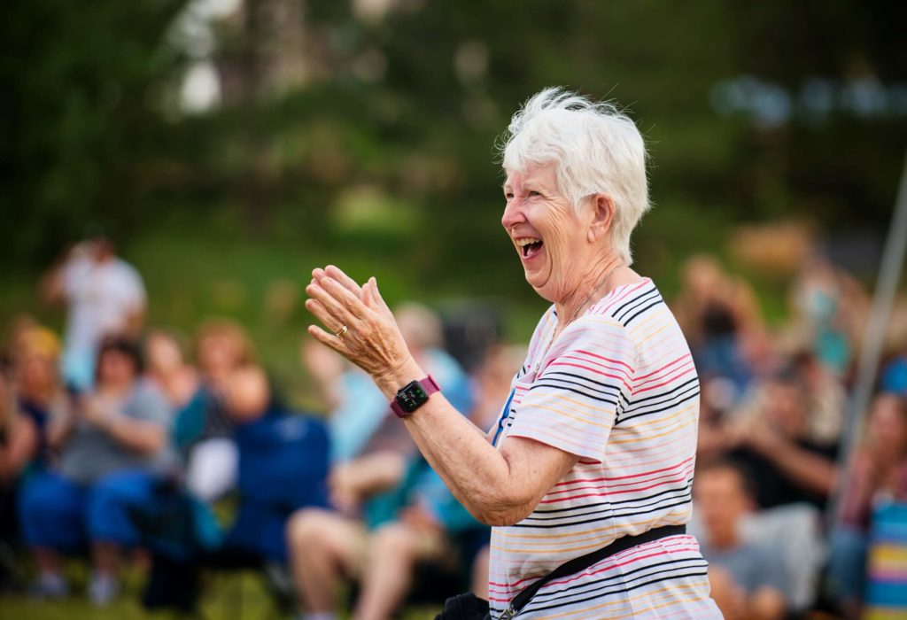 A certified wild woman clapping in front of a crowd.