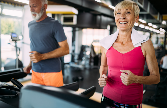 55+ couple running on treadmills