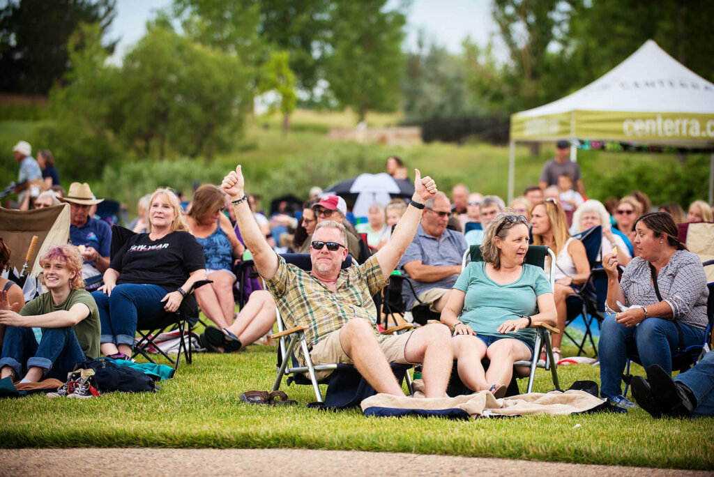 A group of people sitting in lawn chairs, enjoying the outdoors while engaged in casual conversation and relaxation.