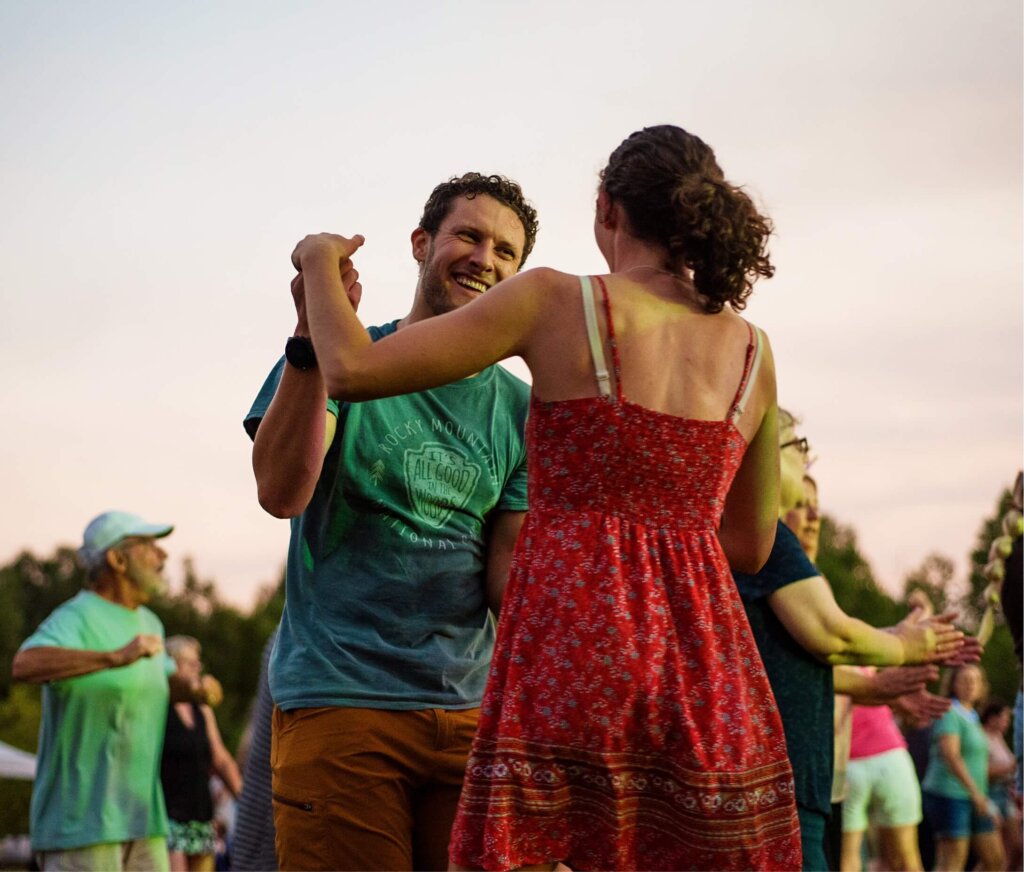 A man and woman Certified Wild dancing at a festival.