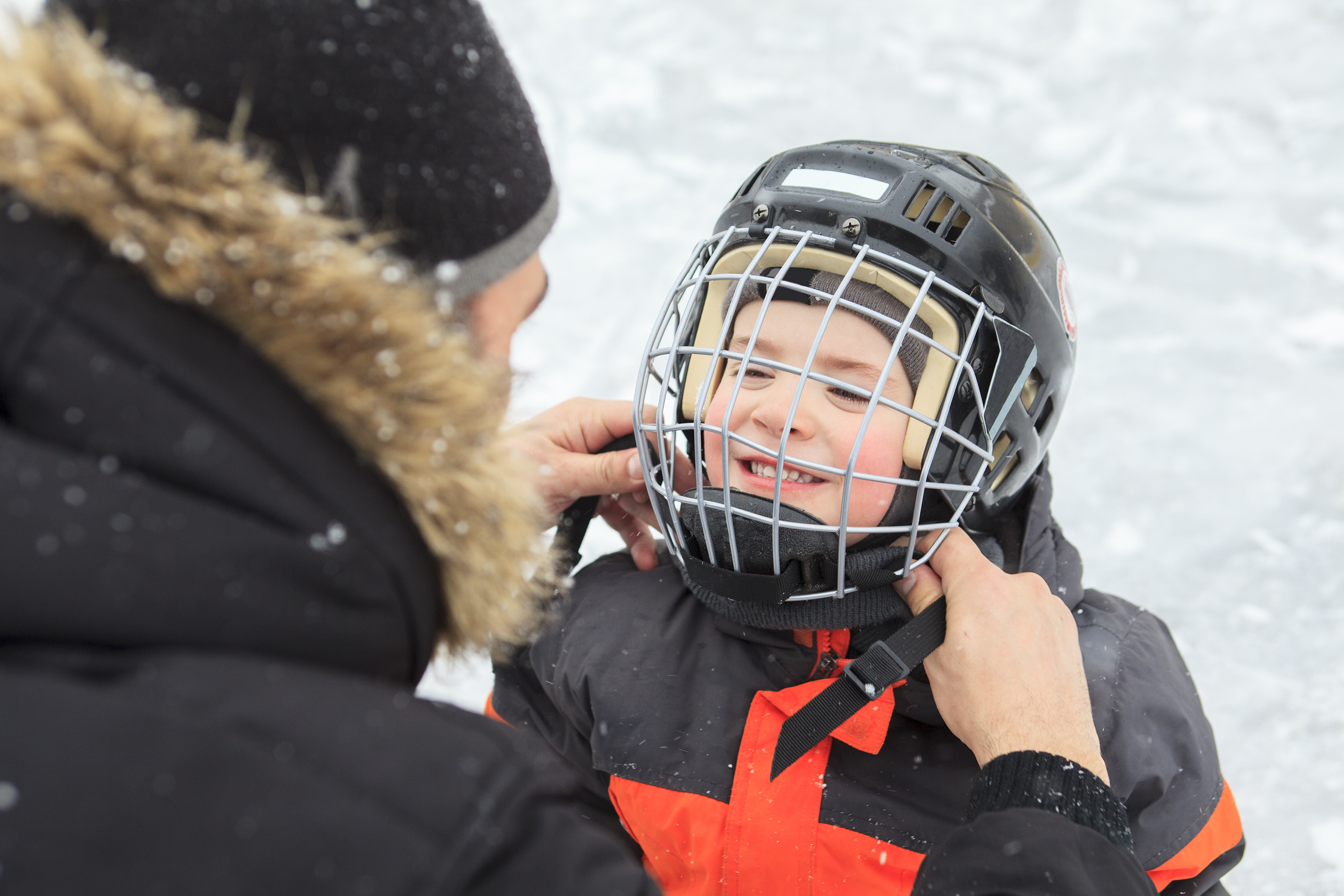 family playing at the skating rink in winter.